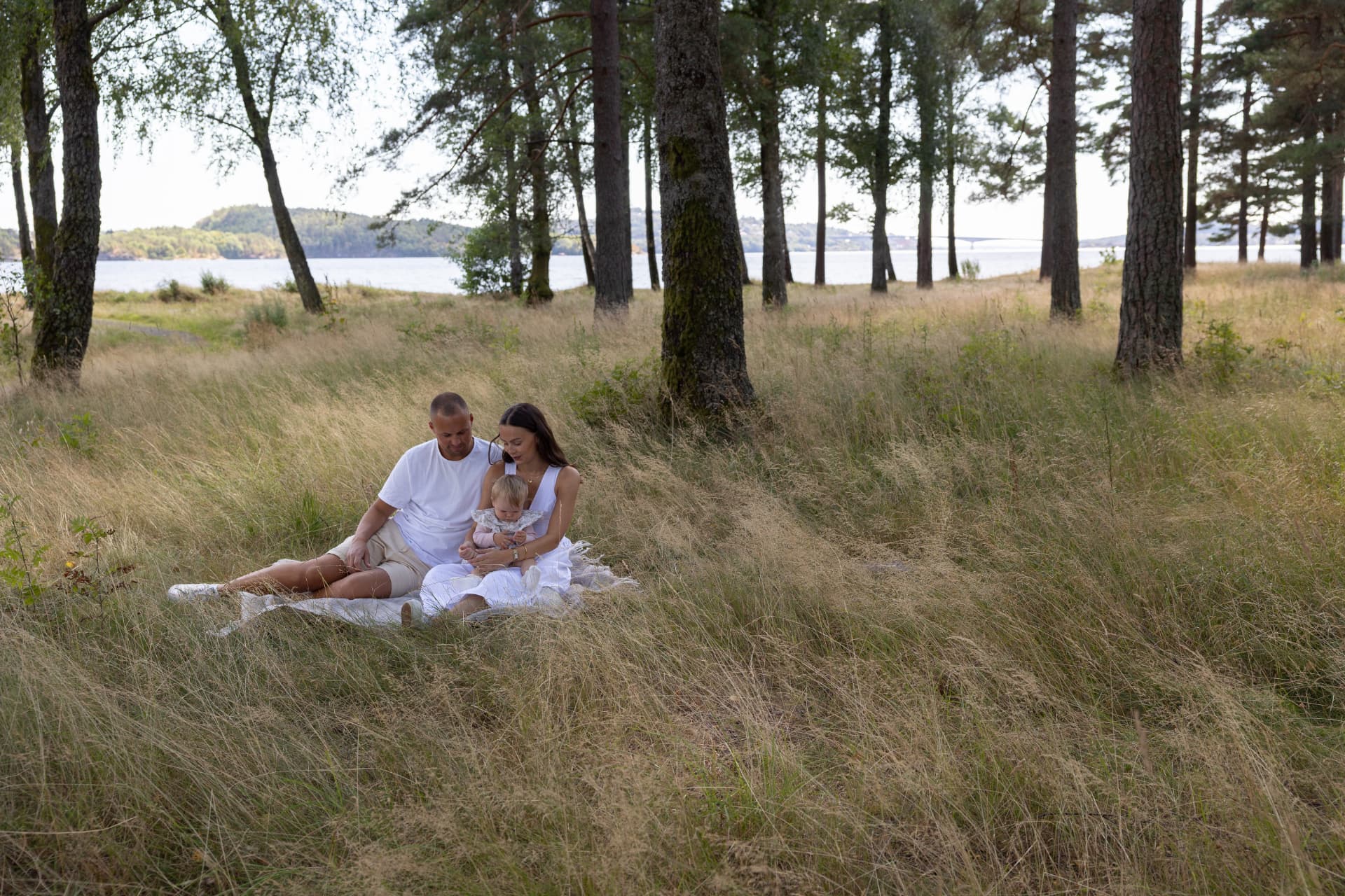 Familie på pledd i skogen ved sjøen